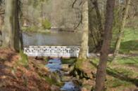 Lávka přes říčku v parku.