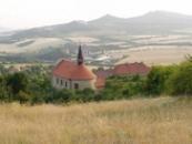 Kostel, fara a zvonice nad údolím potoka Modly.