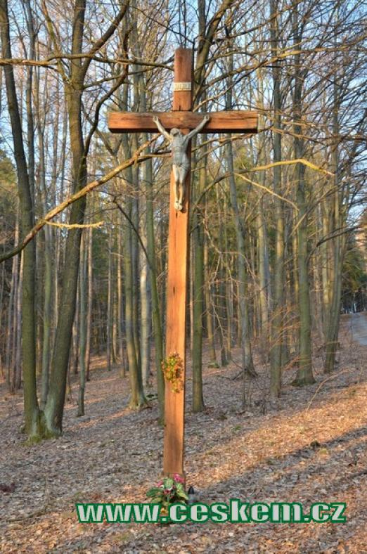 Dřevěný kříž v lese.